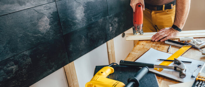 Man cutting wood with electric Jigsaw